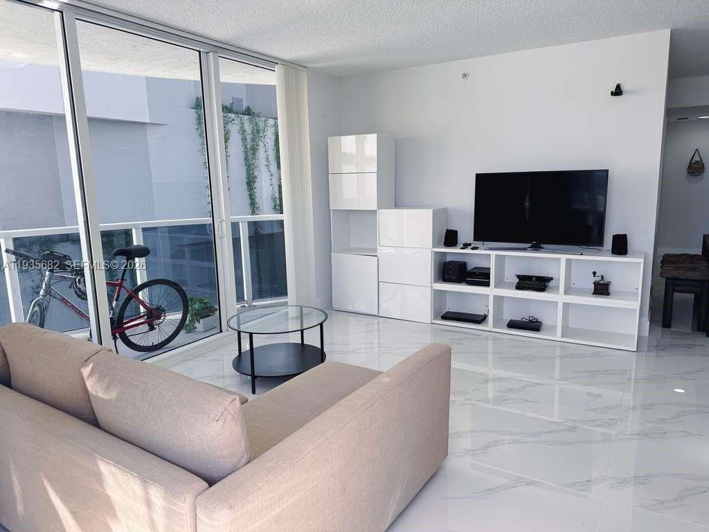 601 Northeast 23rd Street, Unit 706 Miami, FL 33137 - Photo 12 of 25 a living room with furniture and a flat screen tv
