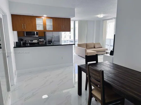 a kitchen with a table chairs refrigerator and window