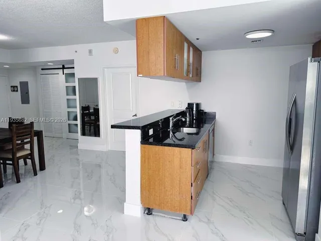 a kitchen with stainless steel appliances granite countertop a refrigerator and a stove