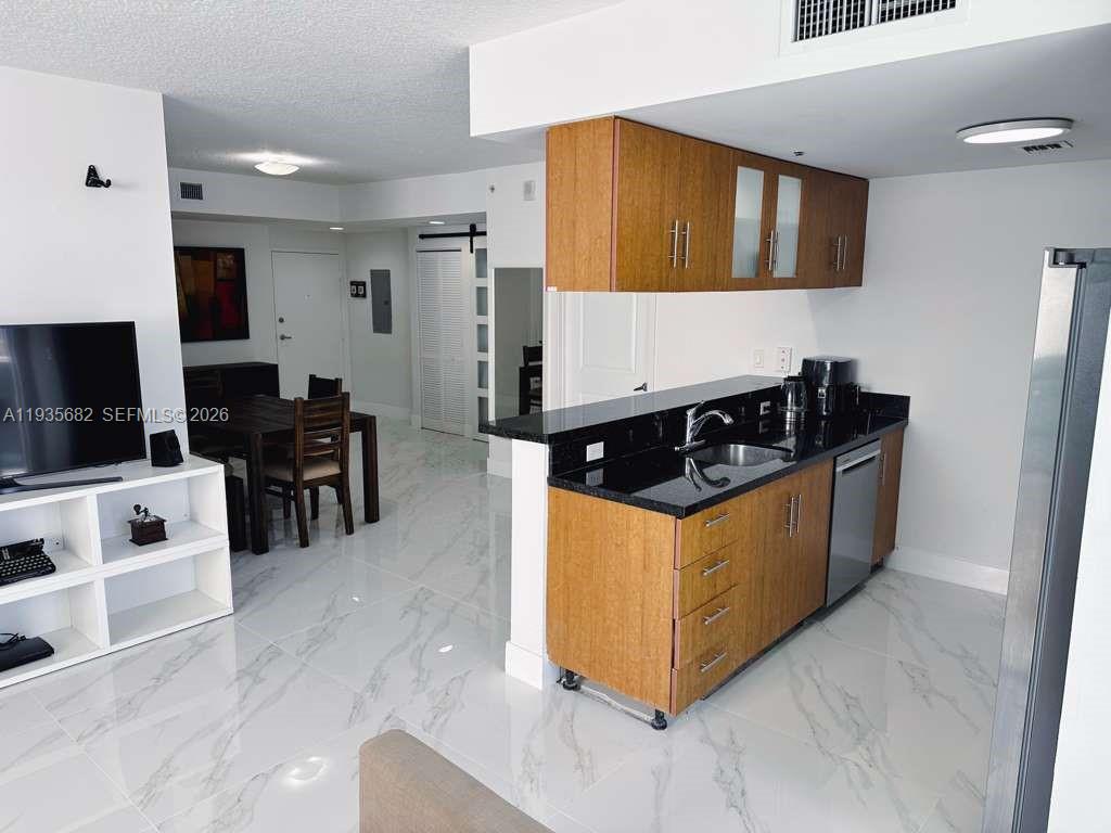 601 Northeast 23rd Street, Unit 706 Miami, FL 33137 - Photo 15 of 25 a kitchen with stainless steel appliances granite countertop a stove a sink and a refrigerator