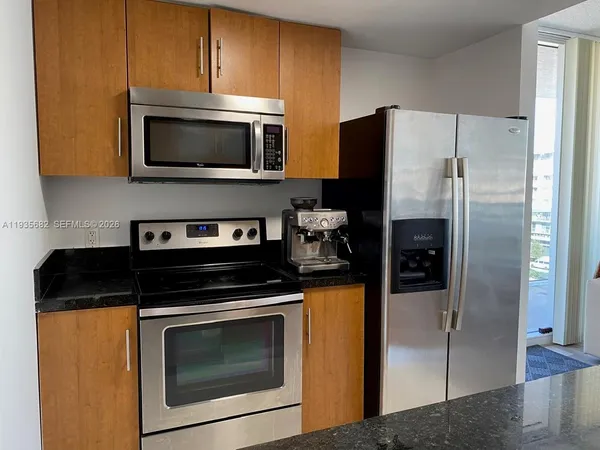 a kitchen with stainless steel appliances granite countertop a stove microwave and refrigerator