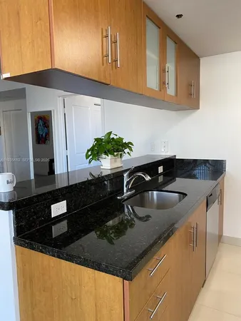 a kitchen with granite countertop a sink a stove and cabinets