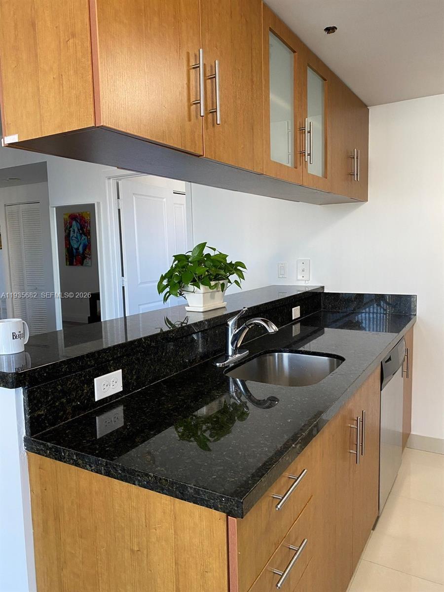 601 Northeast 23rd Street, Unit 706 Miami, FL 33137 - Photo 18 of 25 a kitchen with granite countertop a sink a stove and cabinets