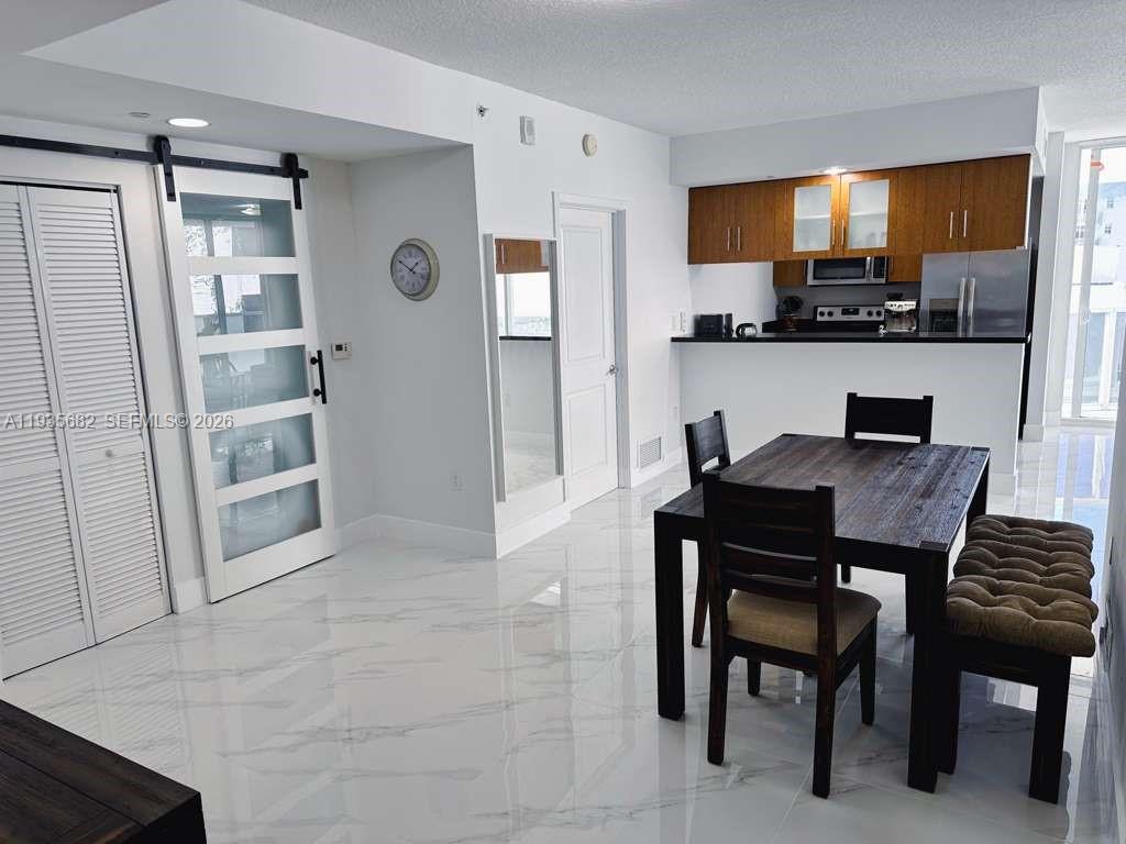601 Northeast 23rd Street, Unit 706 Miami, FL 33137 - Photo 9 of 25 a kitchen with a table and chairs in it