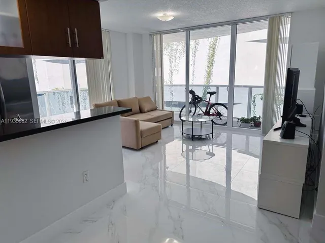 a living room with furniture and large windows