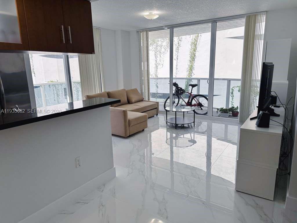 601 Northeast 23rd Street, Unit 706 Miami, FL 33137 - Photo 10 of 25 a living room with furniture and large windows