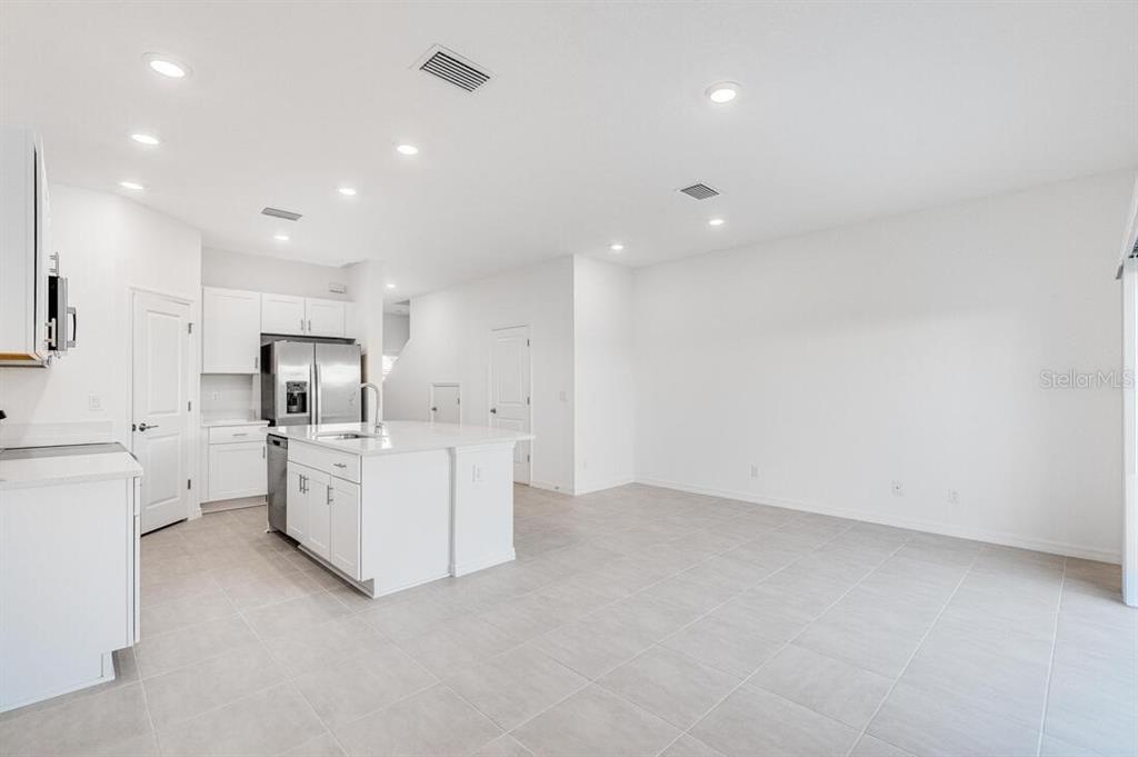 3035 Novara Lane Lakewood Ranch, FL 34211 - Photo 7 of 18 a large white kitchen with white cabinets and white appliances