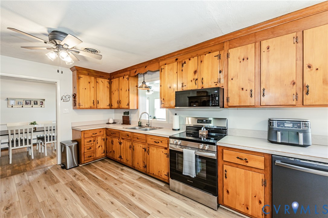 1927 F Street West Point, VA 23181 - Photo 12 of 59 a kitchen with stainless steel appliances granite countertop a stove top oven a sink dishwasher and white cabinets with wooden floor