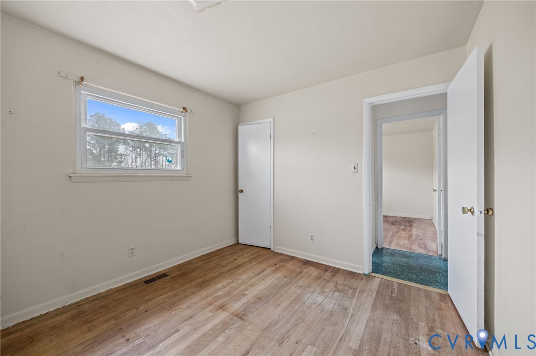 10187 Birch Island Road Wakefield, VA 23888 - Photo 35 of 41 a view of an empty room with wooden floor and a window