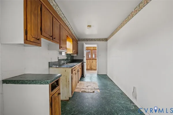 a kitchen with granite countertop a sink a stove and refrigerator