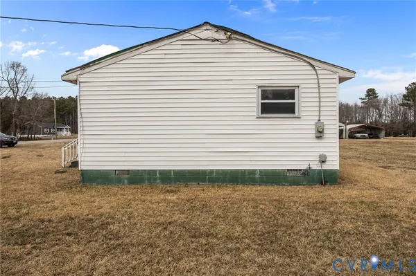 a view of a white house next to a yard