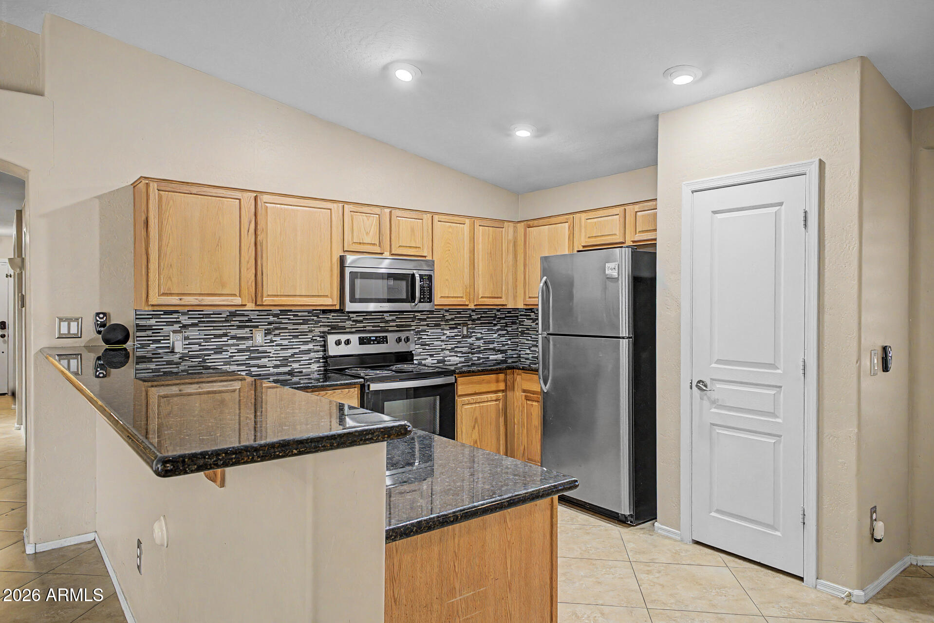 2340 West Apollo Road Phoenix, AZ 85041 - Photo 8 of 26 a kitchen with stainless steel appliances granite countertop a refrigerator a stove a sink and a microwave