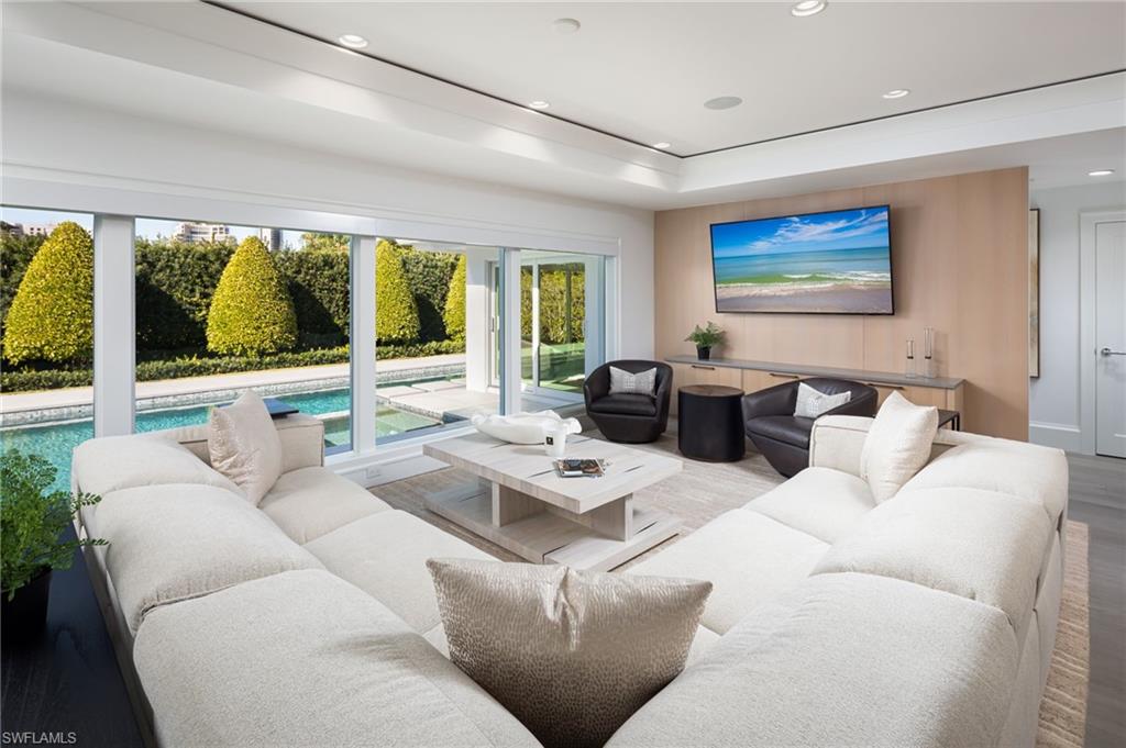512 Neapolitan Lane Naples, FL 34103 - Photo 11 of 35 a living room with furniture and large windows