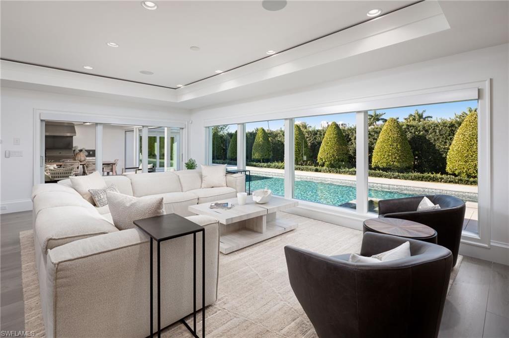512 Neapolitan Lane Naples, FL 34103 - Photo 12 of 35 a living room with furniture and a floor to ceiling window