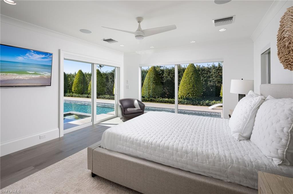 512 Neapolitan Lane Naples, FL 34103 - Photo 20 of 35 a bedroom with a bed and glass door