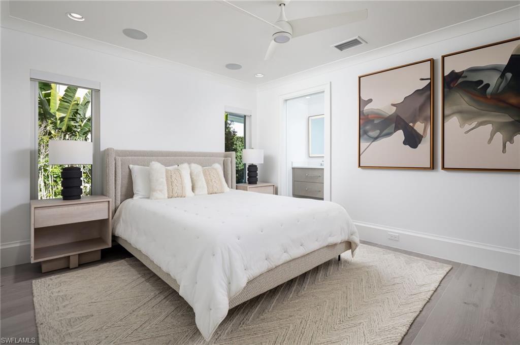 512 Neapolitan Lane Naples, FL 34103 - Photo 22 of 35 a bedroom with a bed and a painting on the wall