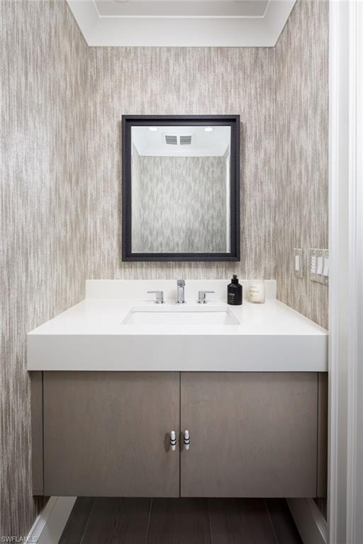 512 Neapolitan Lane Naples, FL 34103 - Photo 23 of 35 a bathroom with a sink and a mirror