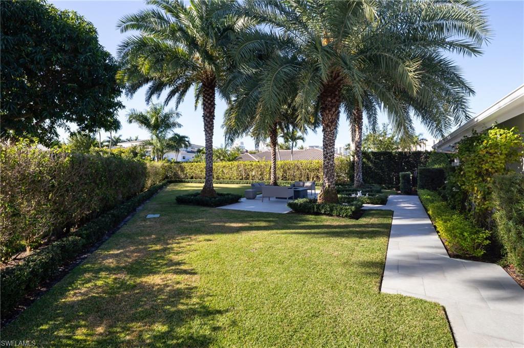 512 Neapolitan Lane Naples, FL 34103 - Photo 25 of 35 a view of backyard with swimming pool and palm tree