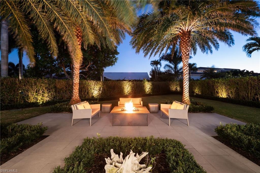 512 Neapolitan Lane Naples, FL 34103 - Photo 26 of 35 a view of a patio with table and chairs couches and potted plants