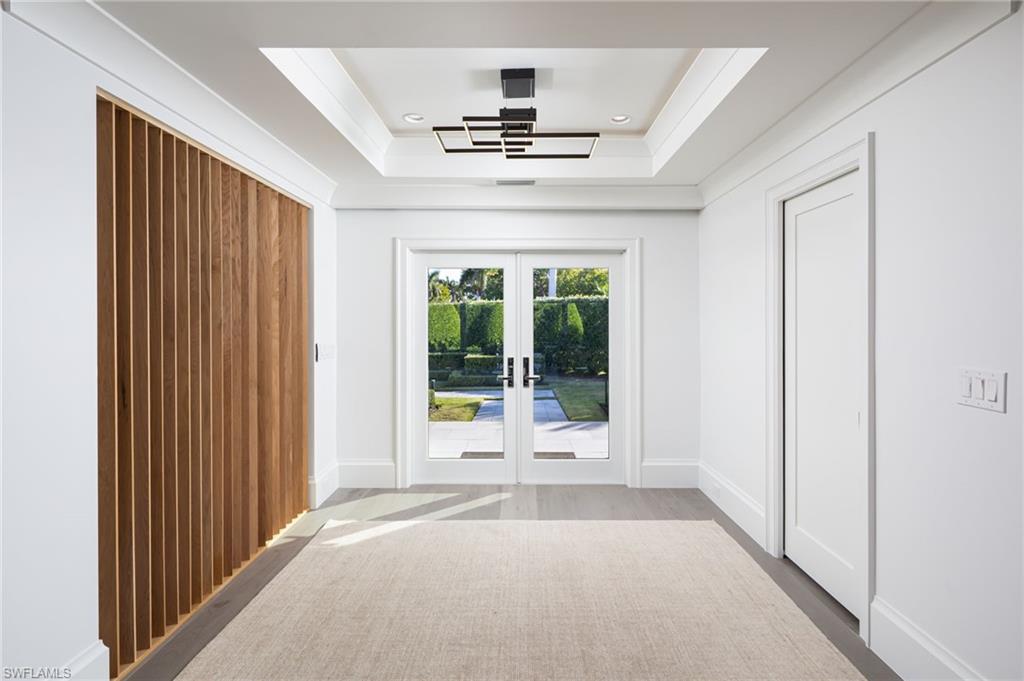 512 Neapolitan Lane Naples, FL 34103 - Photo 5 of 35 a view of a hallway with a chandelier