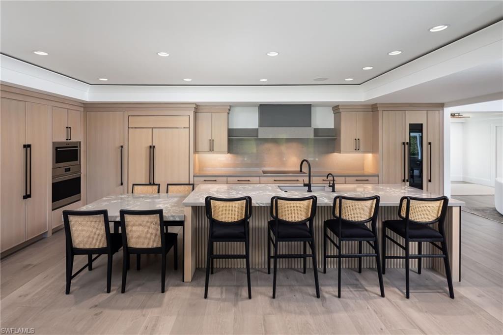 512 Neapolitan Lane Naples, FL 34103 - Photo 10 of 35 a dining room with stainless steel appliances kitchen island granite countertop a table and chairs