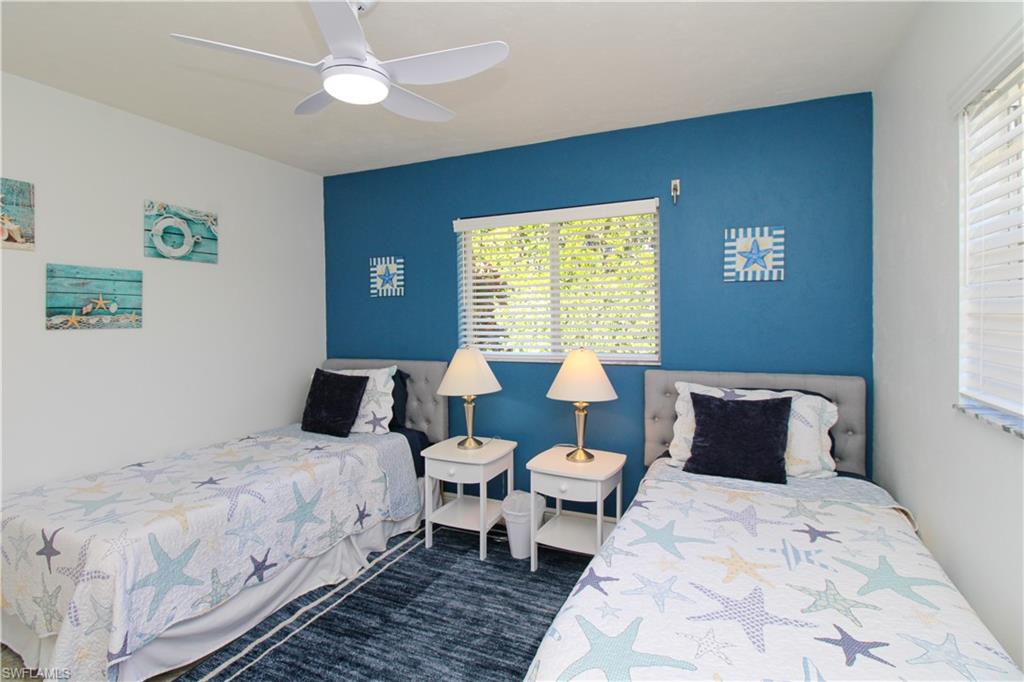516 Gordonia Road Naples, FL 34108 - Photo 26 of 50 a bedroom with a bed and a chandelier