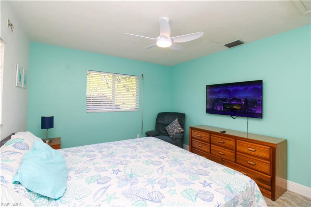 516 Gordonia Road Naples, FL 34108 - Photo 28 of 50 a bedroom with a bed and a flat screen tv