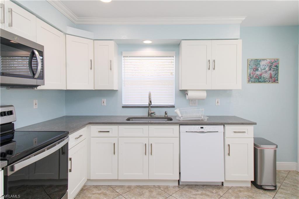 516 Gordonia Road Naples, FL 34108 - Photo 43 of 50 a kitchen with granite countertop white cabinets and stainless steel appliances