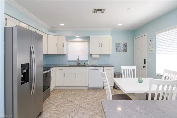 a kitchen with stainless steel appliances granite countertop a refrigerator and a stove top oven