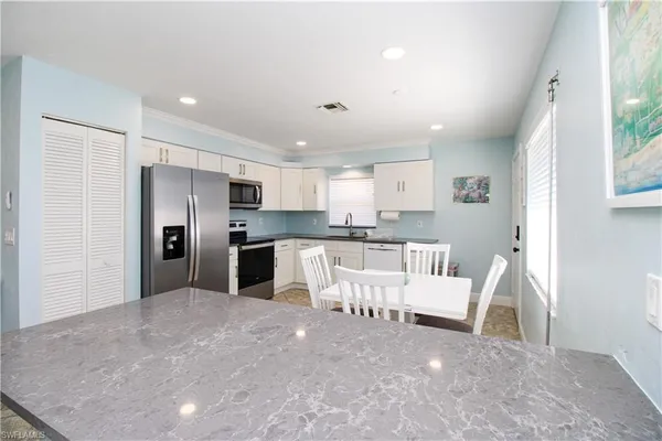 a large white kitchen with white cabinets and stainless steel appliances