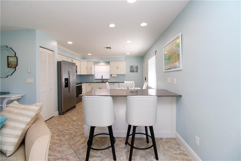 516 Gordonia Road Naples, FL 34108 - Photo 47 of 50 a kitchen with stainless steel appliances kitchen island granite countertop a sink and cabinets