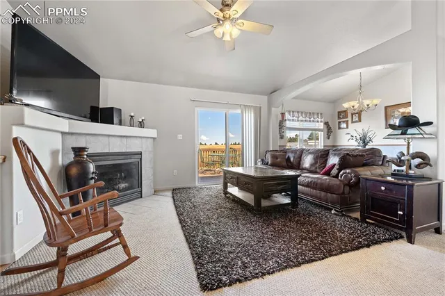 a living room with furniture a flat screen tv and a fireplace