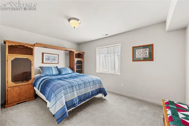 a bedroom with a bed and dresser with mirror