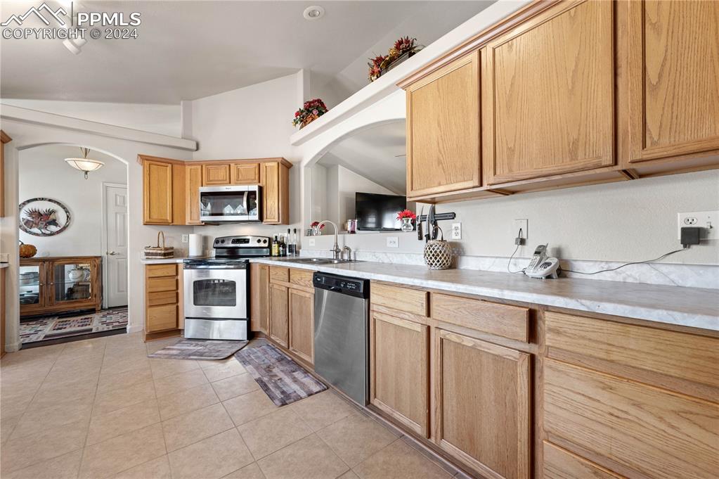 17950 Cumbres Road Peyton, CO 80831 - Photo 3 of 21 a kitchen with kitchen island granite countertop a stove sink and cabinets