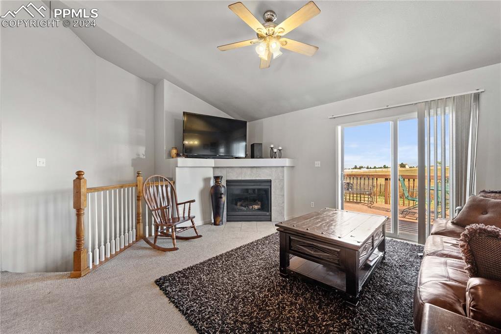 17950 Cumbres Road Peyton, CO 80831 - Photo 5 of 21 a living room with furniture a fireplace and a flat screen tv