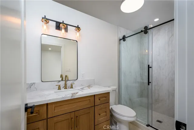 a bathroom with a granite countertop sink toilet and shower