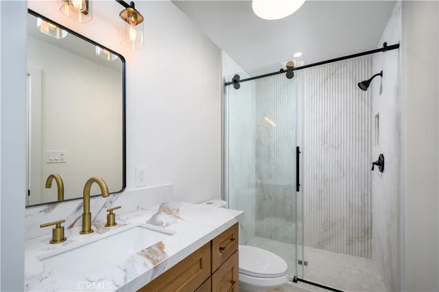 a bathroom with a granite countertop sink toilet and shower