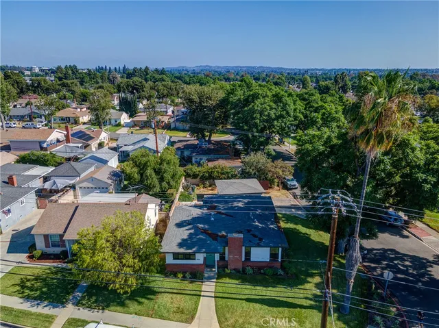 an aerial view of residential houses with outdoor space and trees