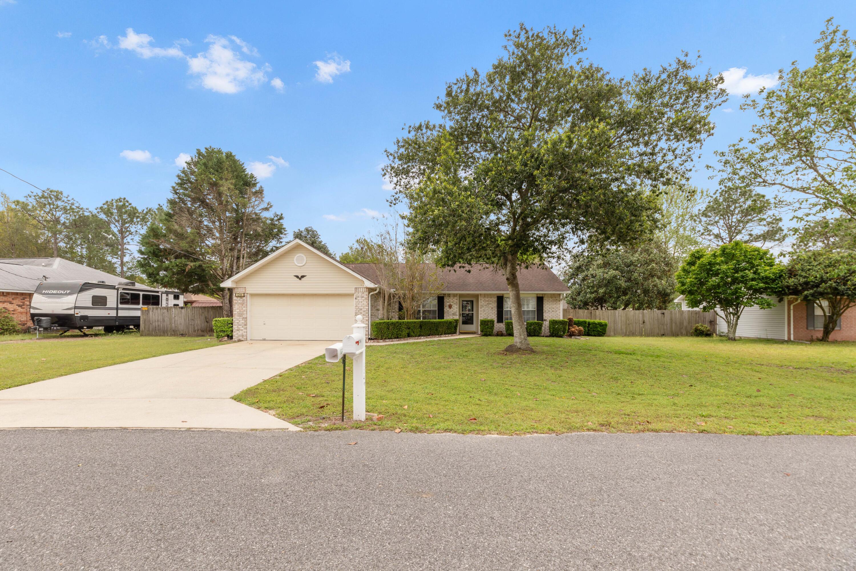 1244 Jefferyscot Drive Crestview, FL 32536 - Photo 2 of 40 a house with a yard and a large tree