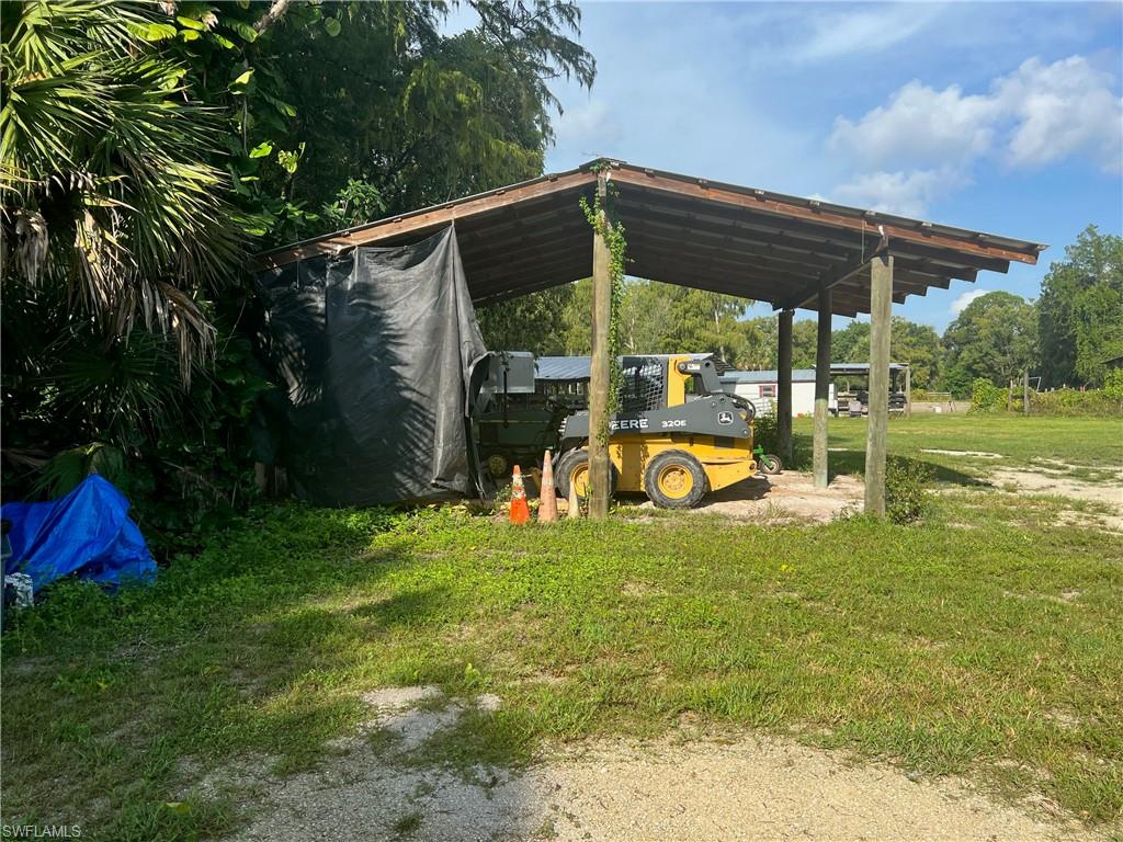 2170 Rock Road Naples, FL 34120 - Photo 5 of 15 a view of a backyard with table and chairs under an umbrella