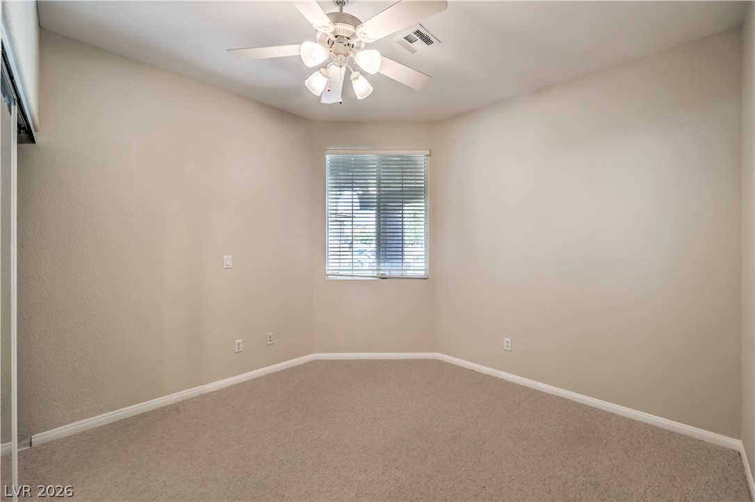 3713 Spring Shadow Road Las Vegas, NV 89129 - Photo 28 of 37 This naturally illuminated bedroom offers comfort with plush carpeting and a ceiling fan.