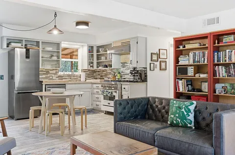 a living room with furniture and a kitchen view