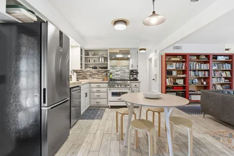 a kitchen with stainless steel appliances granite countertop a refrigerator and a stove top oven