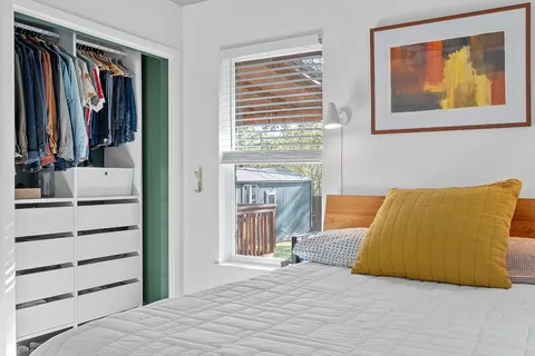 a bedroom with a bed and a painting on the wall