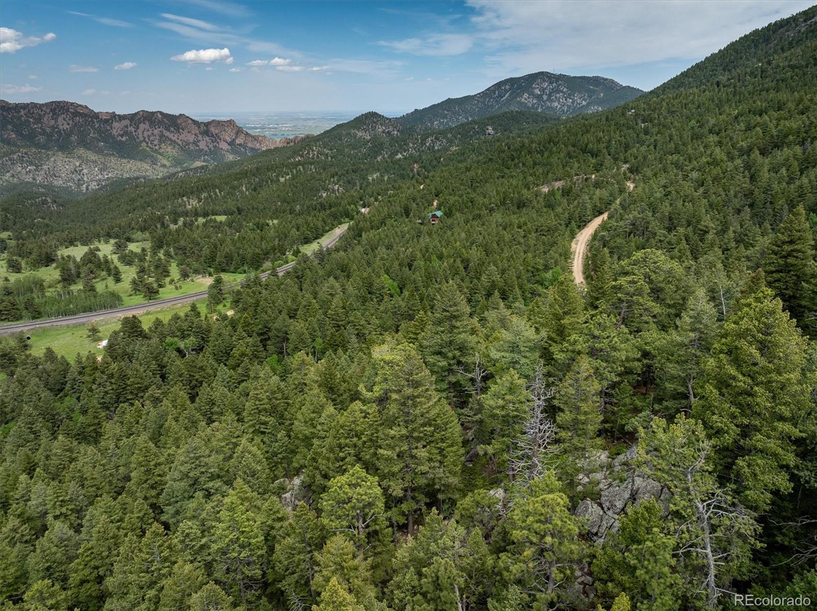 1546 Chute Road Golden, CO 80403 - Photo 8 of 36 a view of a lush green hillside and a mountain