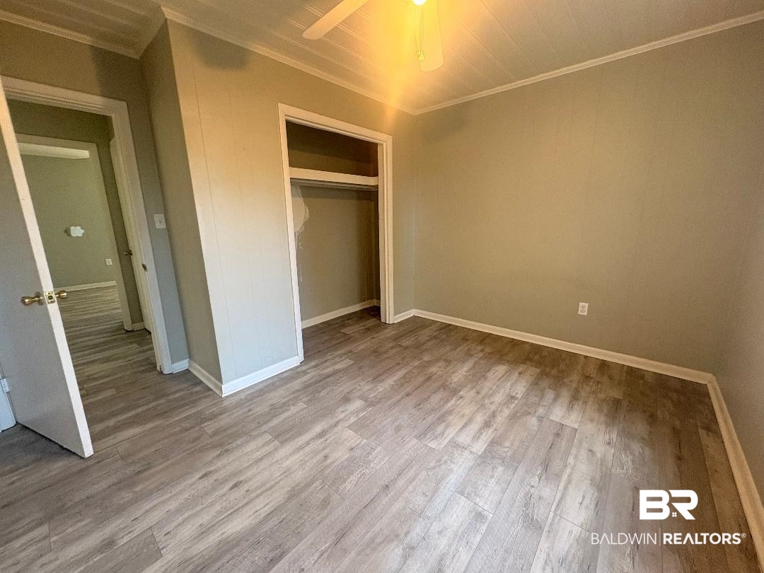 9330 Pinewood Avenue, Unit S 1 2 3 4 Elberta, AL 36530 - Photo 11 of 12 Unfurnished bedroom with crown molding, a closet, ceiling fan, and light wood finished floors