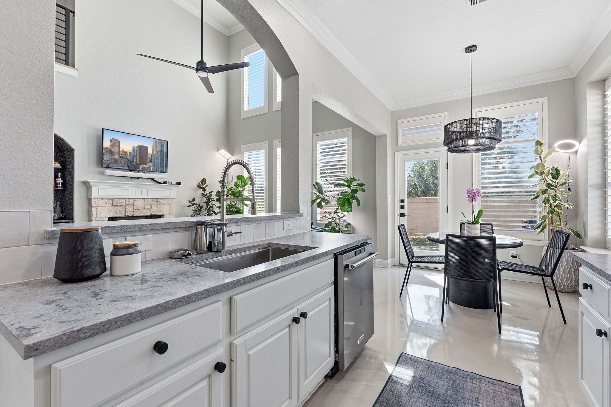 5000 Mission Oaks Boulevard, Unit 30 Austin, TX 78735 - Photo 12 of 31 Kitchen with white cabinets, crown molding, plenty of natural light, a stone fireplace, and light stone countertops