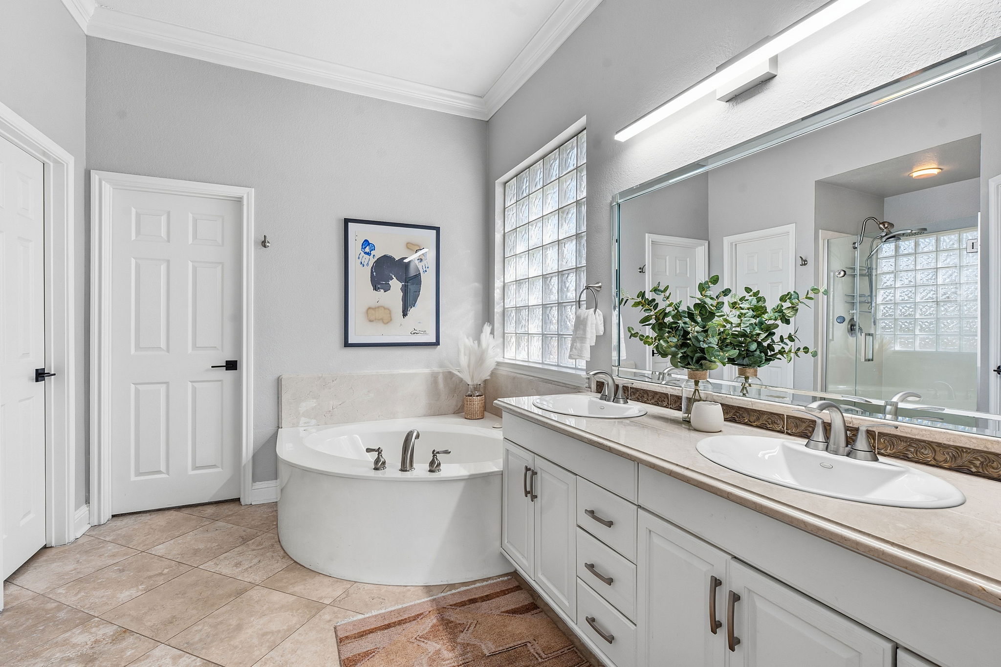 5000 Mission Oaks Boulevard, Unit 30 Austin, TX 78735 - Photo 14 of 31 Primary bathroom with a bath, double vanity, a stall shower, and light tile patterned floors.5000 Mission Oaks Dr #30