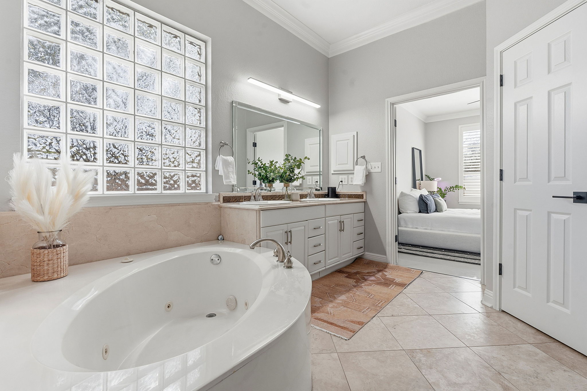 5000 Mission Oaks Boulevard, Unit 30 Austin, TX 78735 - Photo 15 of 31 Primary bathroom with a bath, double vanity, a stall shower, and light tile patterned floors.5000 Mission Oaks Dr #30
