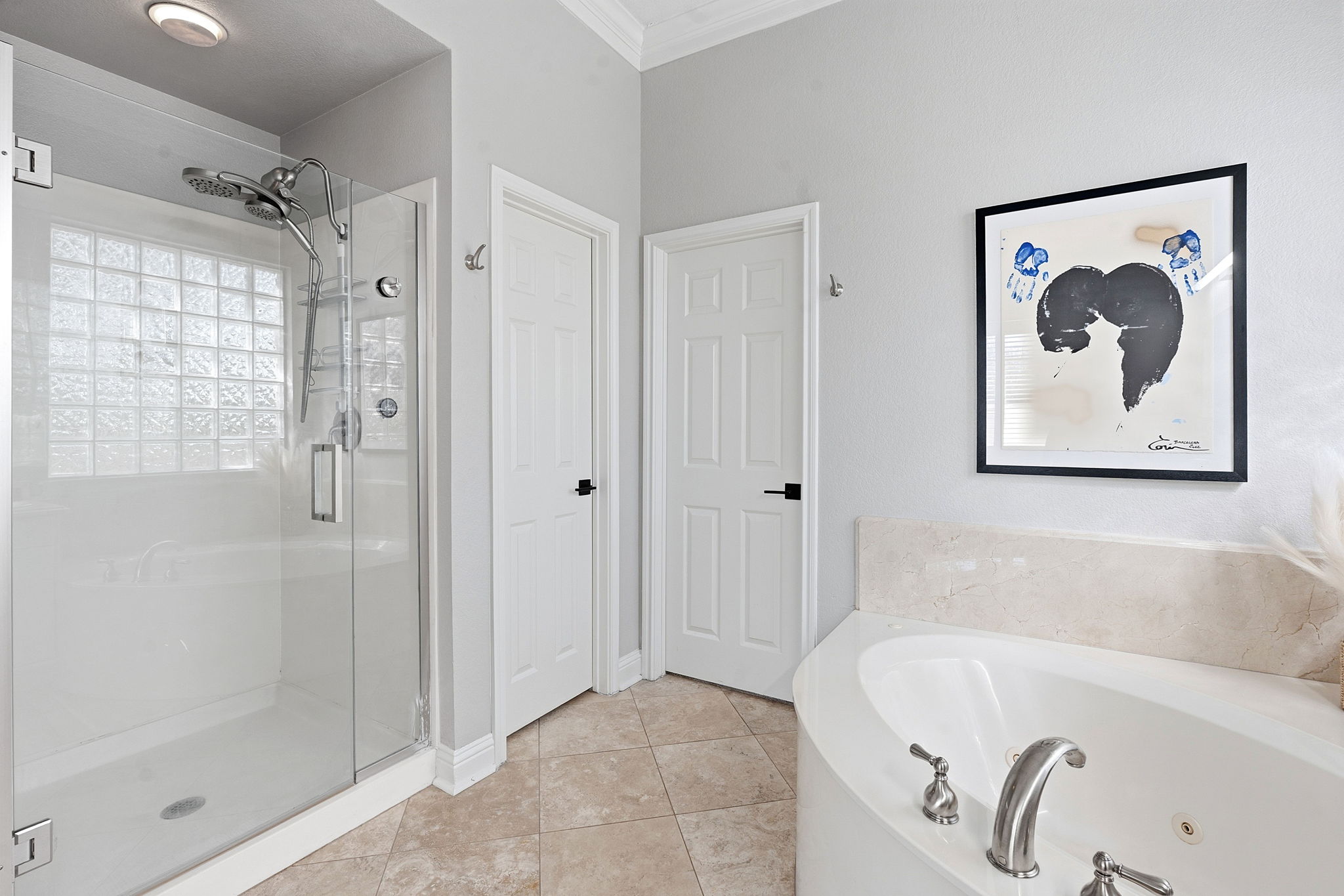 5000 Mission Oaks Boulevard, Unit 30 Austin, TX 78735 - Photo 16 of 31 Primary bathroom with a bath, double vanity, a stall shower, and light tile patterned floors.5000 Mission Oaks Dr #30
